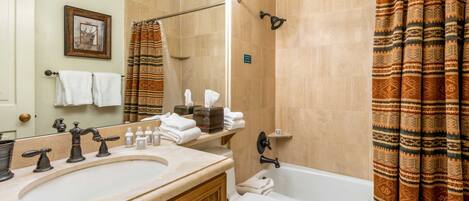 A bathroom with a sink, mirror, towel rack, shower curtain, and a toilet.