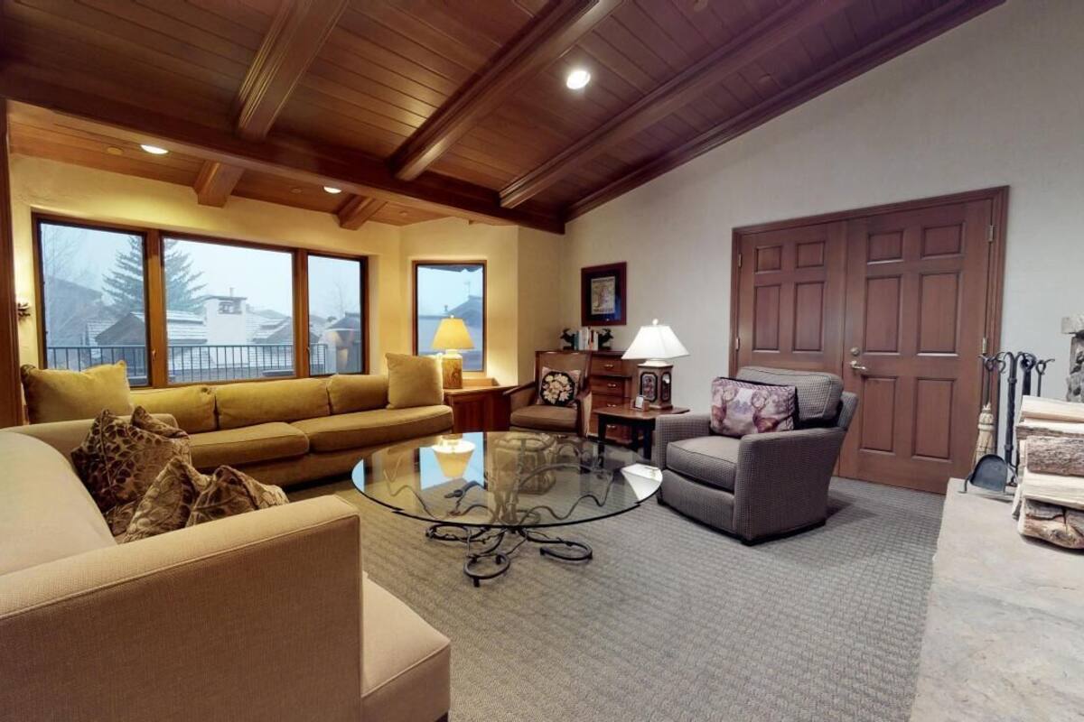 A cozy living room with a sofa, armchair, and a glass coffee table.