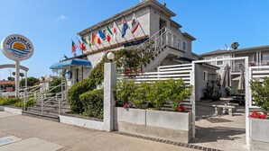 Entrada de hotel con un letrero que dice "Ocean Park Inn" y varias banderas.