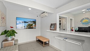 Un moderno vestíbulo de hotel con un televisor grande, un banco, una planta y un letrero que indica Ocean Park en Santa Mónica.