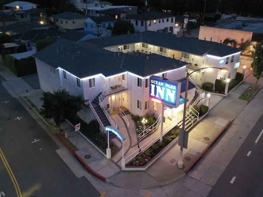 Un edificio de varios pisos con un llamativo letrero que dice “Ocean Inn”, que incluye una escalera y un pequeño jardín.