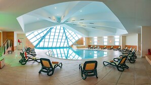 A large indoor swimming pool with a unique ceiling design, surrounded by lounge chairs. - Monte Baia Uludag (Bursa)