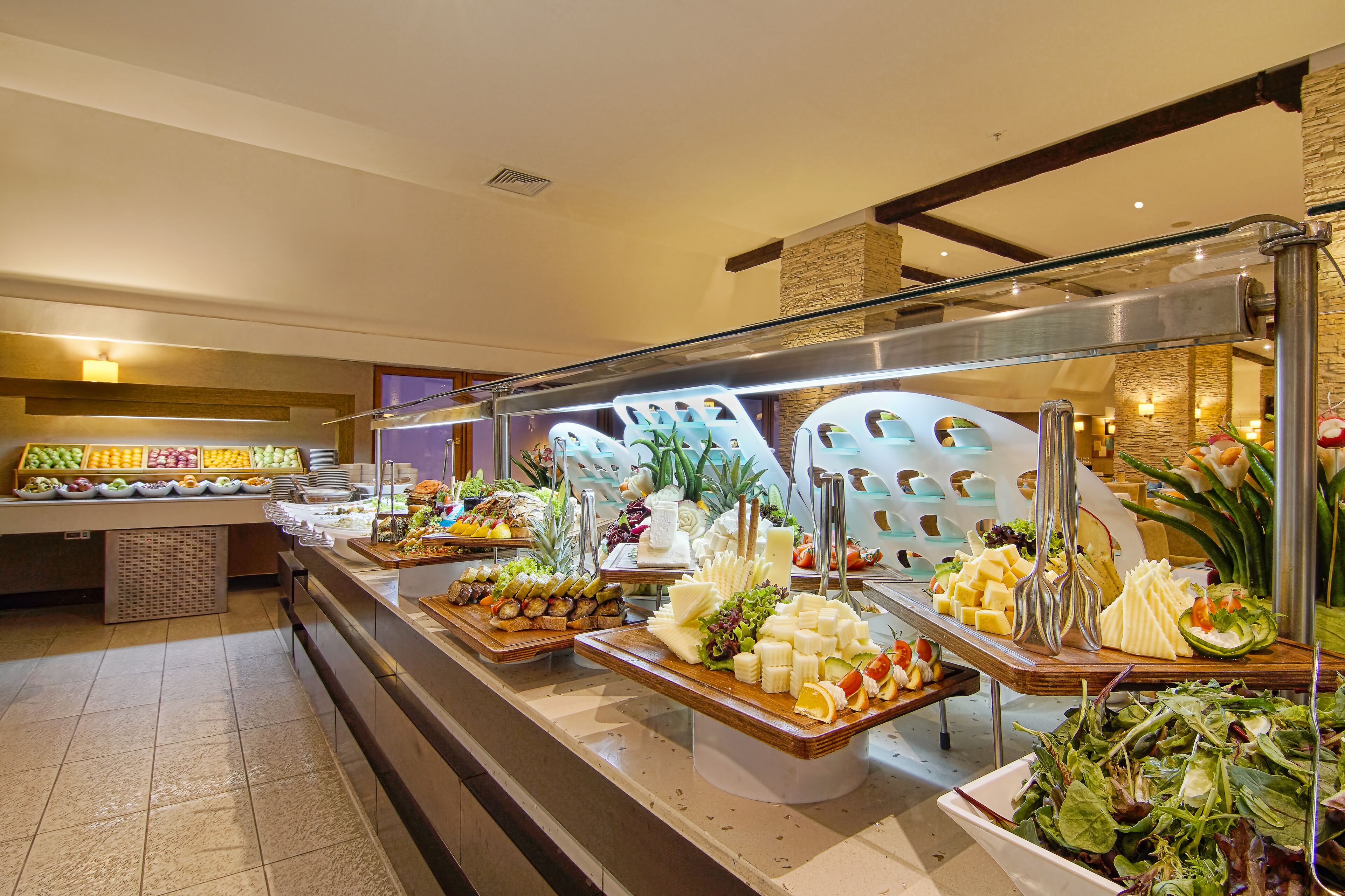 A buffet with various food items including fruits, cheeses, and salads.