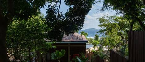 Una cabaña de madera con vista al mar y montañas al fondo.