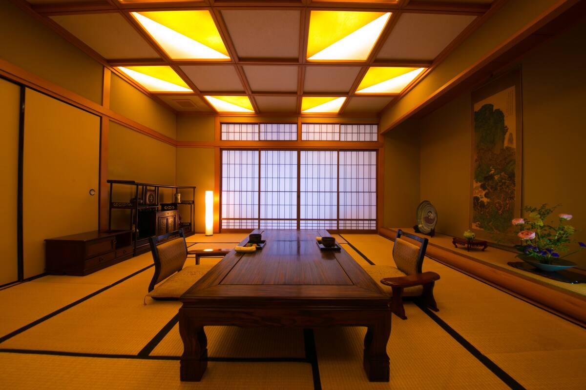 A traditional Japanese room with tatami flooring, a low wooden table, and sliding doors.