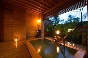 Um spa de madeira com hidromassagem, piso de madeira e vista para o exterior.