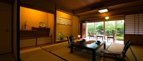 Une pièce de style japonais traditionnel, avec un sol recouvert de tatamis, une table basse et des chaises.