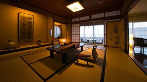 A traditional Japanese room with tatami flooring, a low table, and chairs. - Ibusuki Shusuien (Ibusuki)