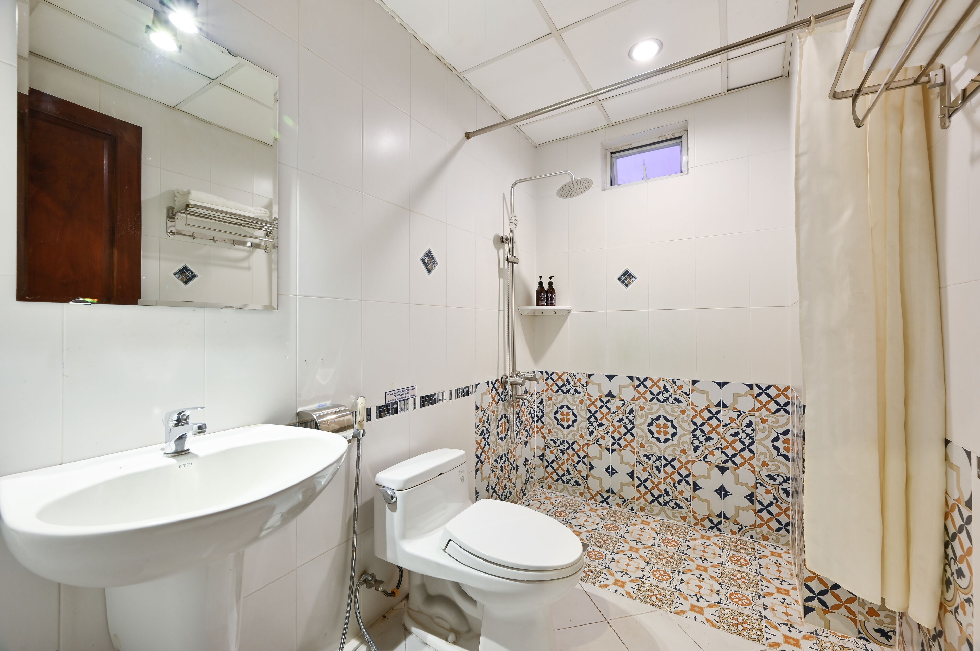 A bathroom with a white sink, toilet, and shower.