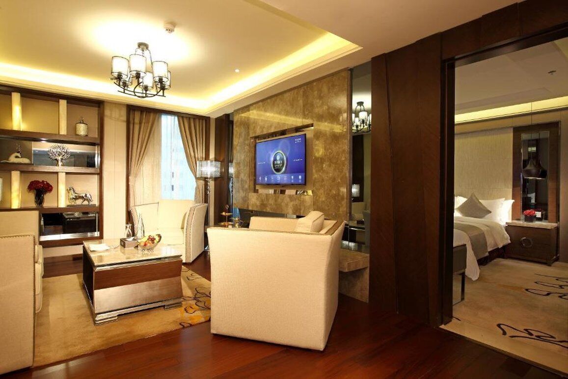 Une chambre d’hôtel moderne dotée d’un espace salon, d’un téléviseur fixé au mur et d’un lit offrant une vue agréable.