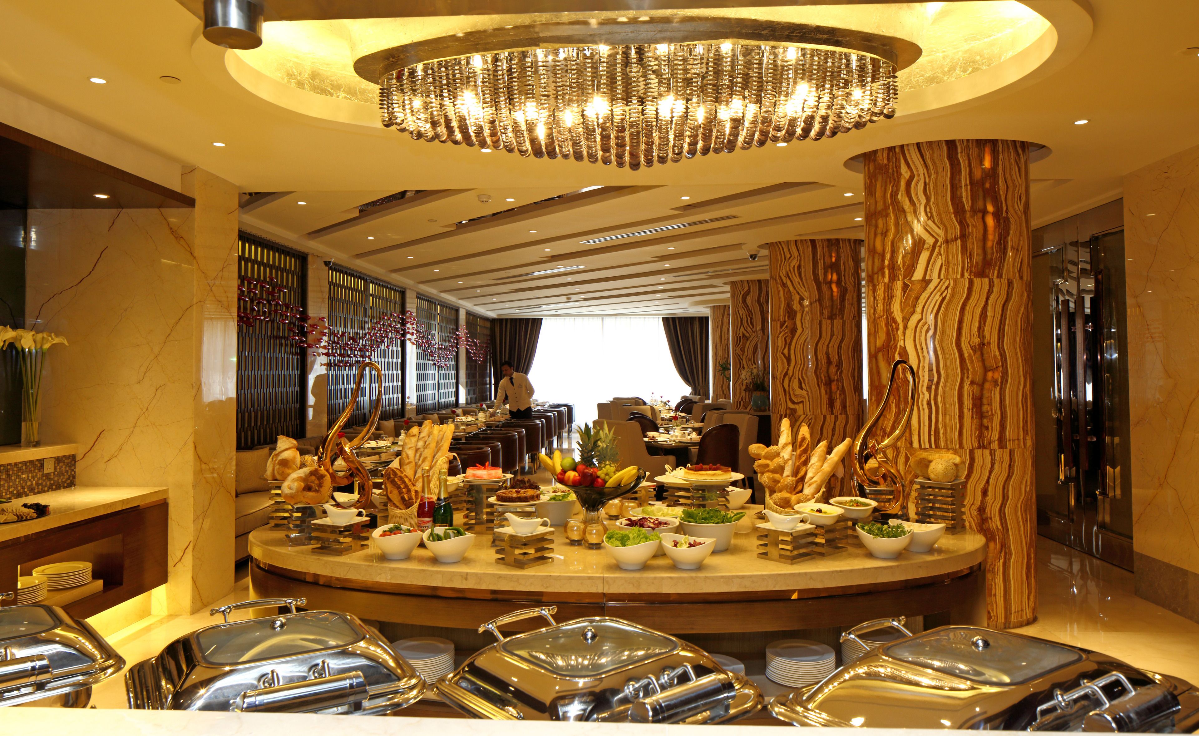 A buffet setup with various food items and a central decorative light fixture.