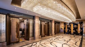 A spacious lobby with a marble floor, a large chandelier, and modern decor. - Braira Hotel Olaya (Riyadh)