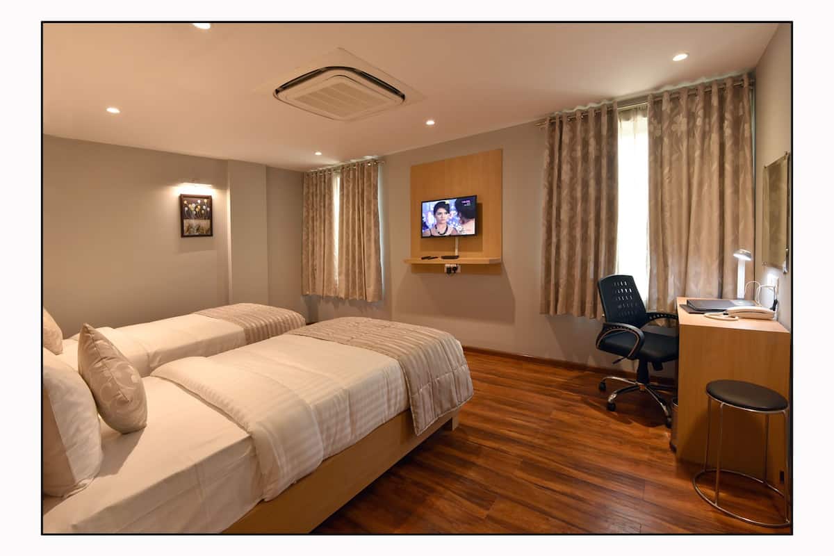 Executive Deluxe Room | Caja de seguridad en la habitación, escritorio y camas extra