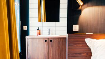 A hotel room with a wooden wardrobe, a white bed, and a star-patterned floor.