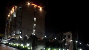 A hotel with a prominent sign reading "ASHIWA HOTEL" at night.