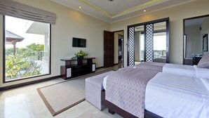 A modern bedroom with a large bed, a ceiling fan, a TV, and a view of the outdoors. - Casa de Balangan by Exotiq Villa Holidays (Jimbaran)