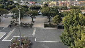 A parking lot with trees, a playground, and a view of a coastal town. - B&B La finestra sulla valle (Agrigento)