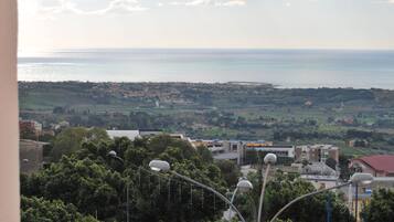 Eine Küstenstadt mit Gebäuden, Bäumen und Blick auf das Meer.