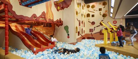 An indoor play area with a slide, ball pit, and various play structures.