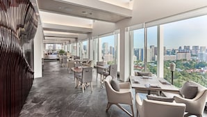 Eine moderne Hotellobby mit Blick auf die Stadt, geräumigen Sitzgelegenheiten und einer hohen Decke.