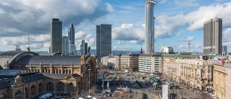 Un paisaje urbano con edificios históricos, una torre moderna y una línea de tranvía.