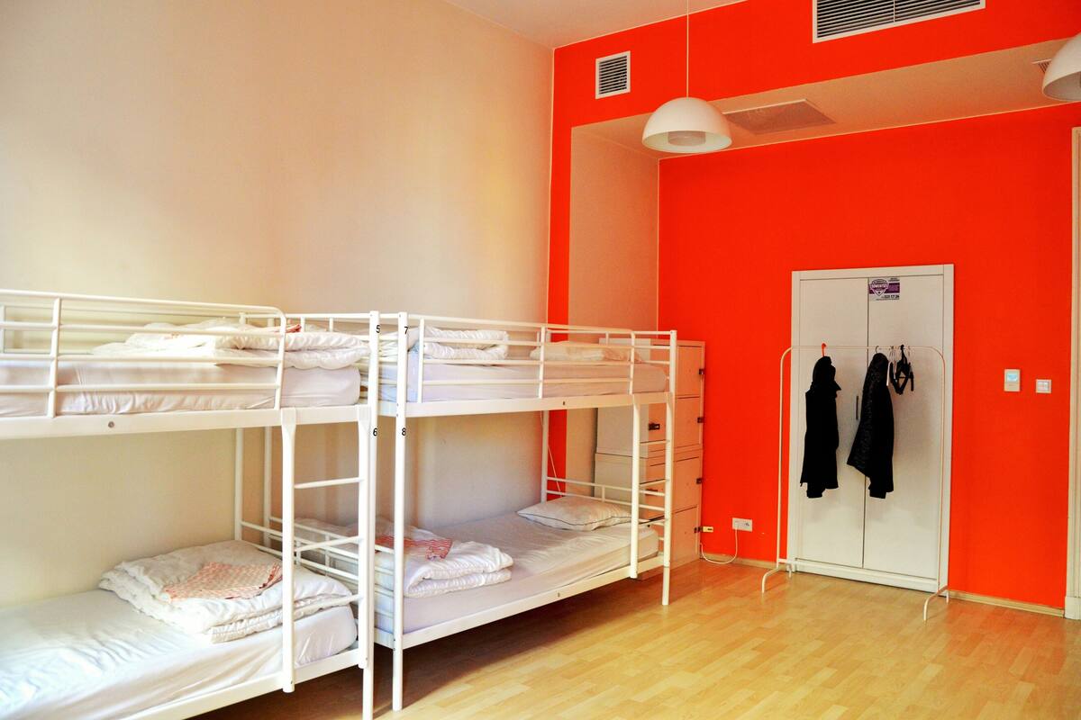 Habitación con literas, un armario y perchero.