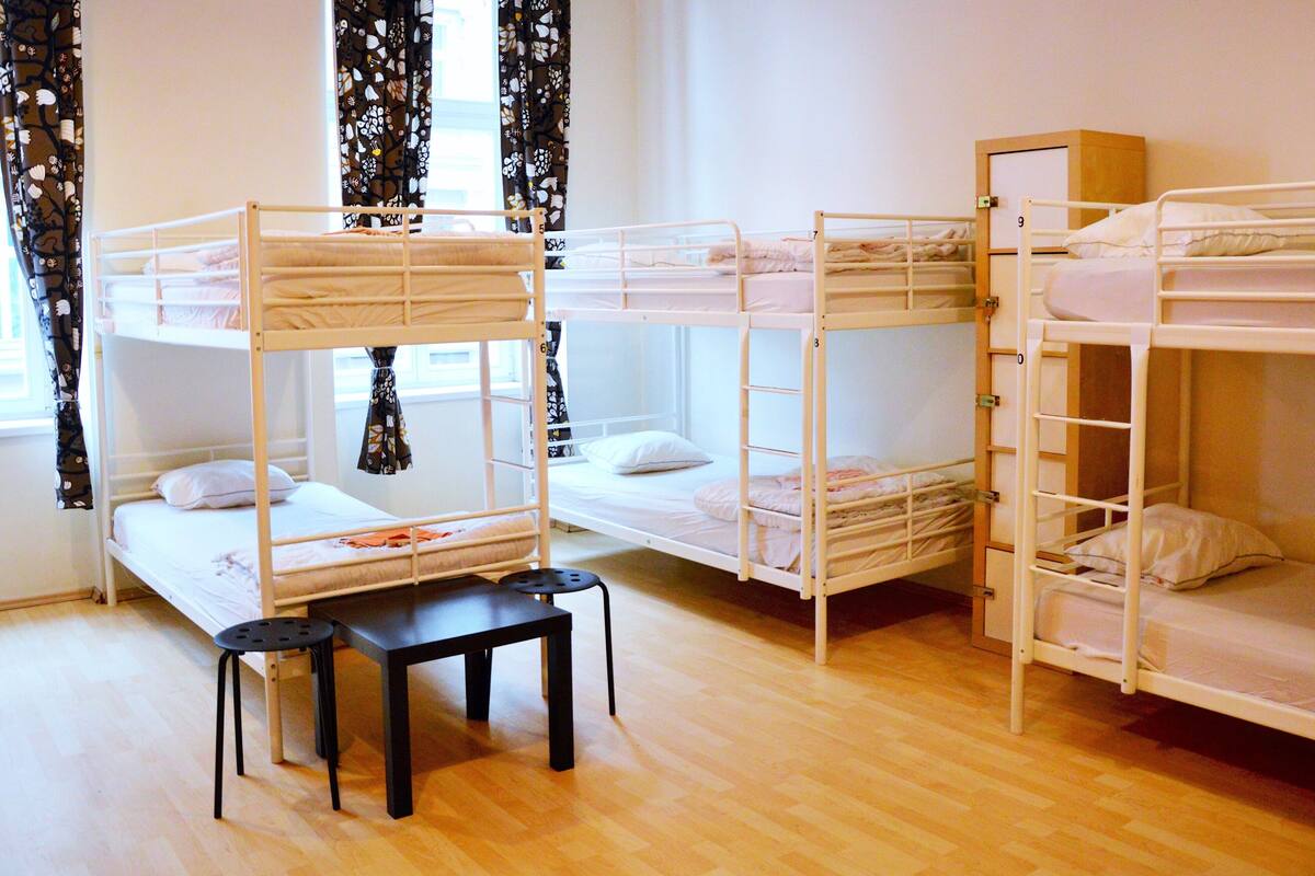 Un dormitorio con literas, una mesita y una silla.