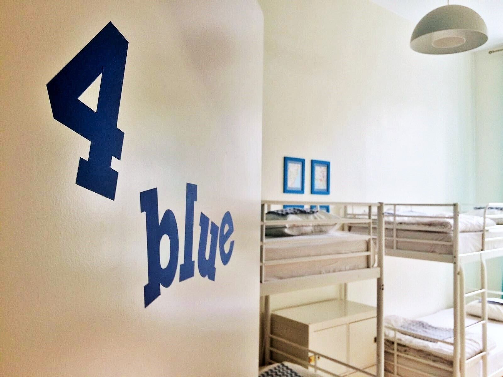 A bunk bed room with a wall sign reading "blue" and the number "4".