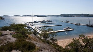 A marina with boats docked at piers, surrounded by rocky terrain and sparse vegetation.