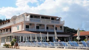 A two-story hotel with balconies and a covered outdoor seating area. - Alkion Hotel Sidari (Corfu)