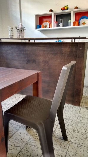 A dining area with a wooden table and a modern chair. - Hostal Don Miguel Cartagena de Indias (Cartagena)