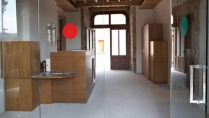 Een modern interieur met een receptiebalie, houten plafond en grote ramen.