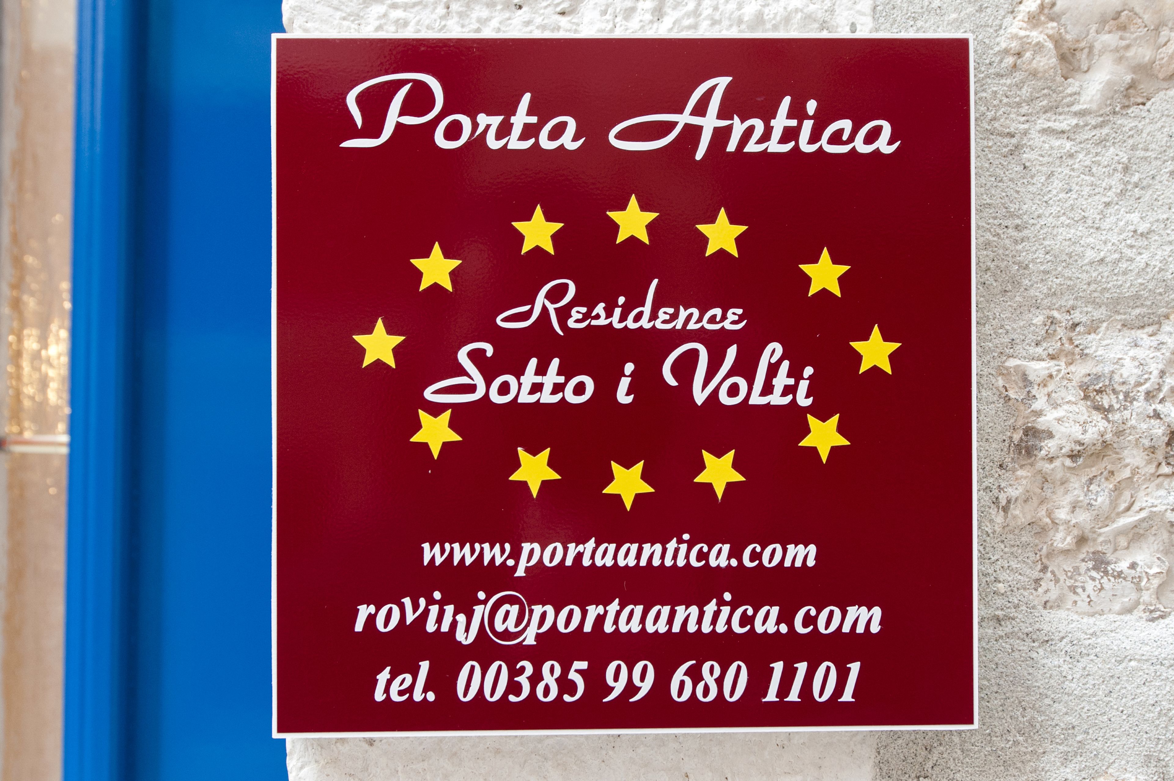 En skylt med texten ”Porta Antica Residence Sotto i Volti” och kontaktuppgifter.