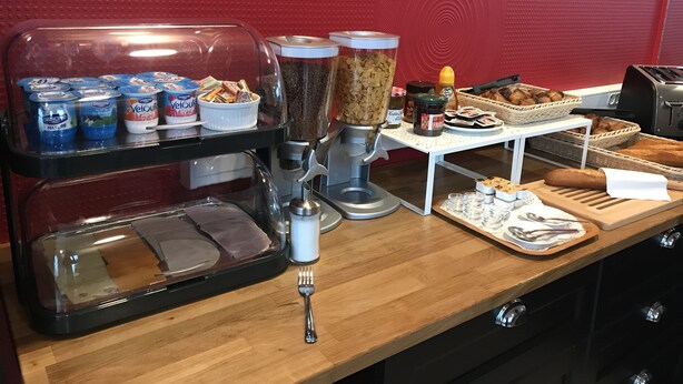 A breakfast buffet with yogurt, cereal, and bread. - Hôtel de l'Europe (Toul)