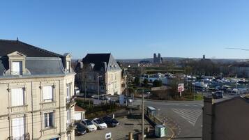A view of a cityscape with historic buildings, a marina, and a distant cathedral.