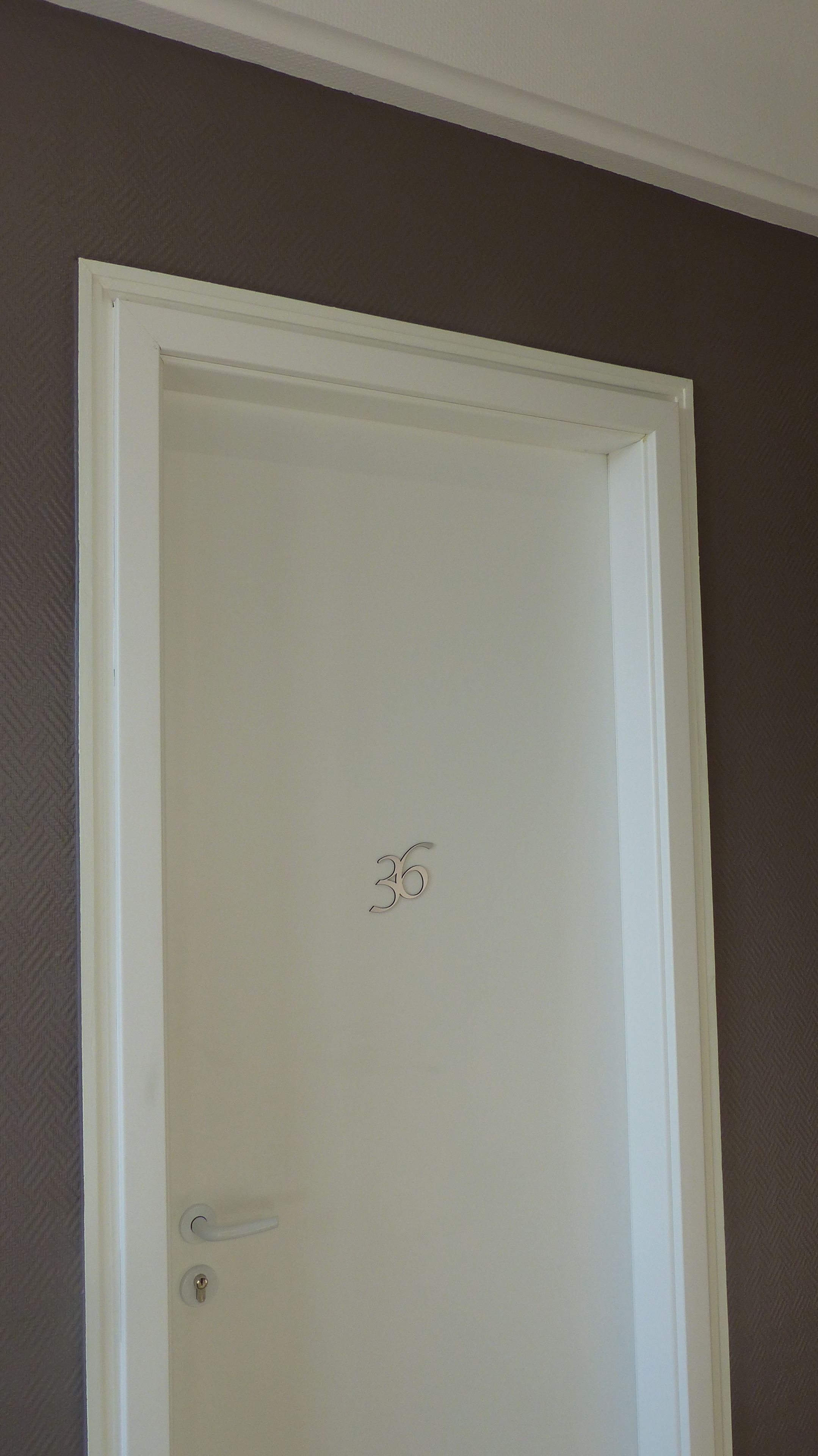 A white door with a number "30" on it, a door handle, and a keyhole.