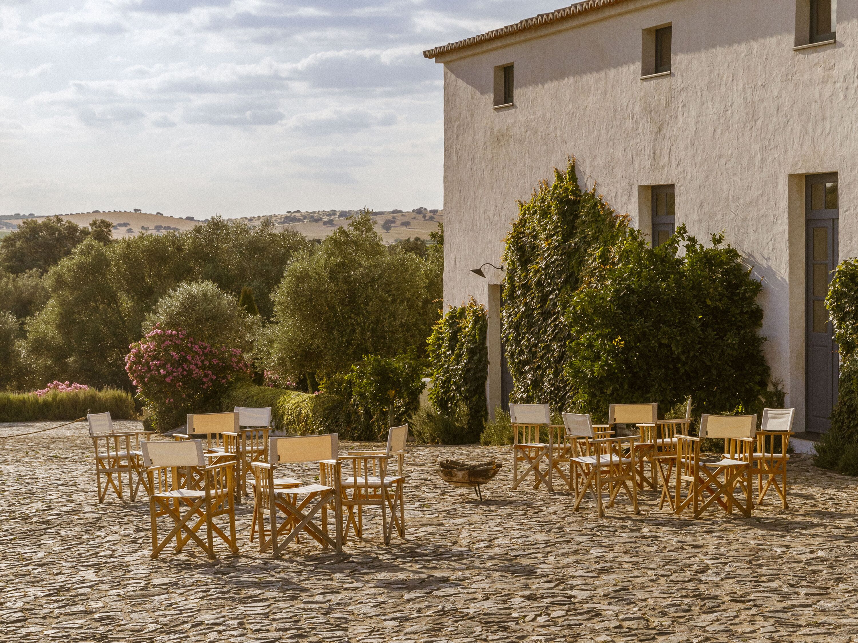 A courtyard with outdoor seating and a building with a white facade.