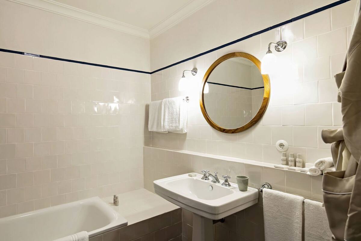 Ein Badezimmer mit Badewanne, Waschbecken und Spiegel.