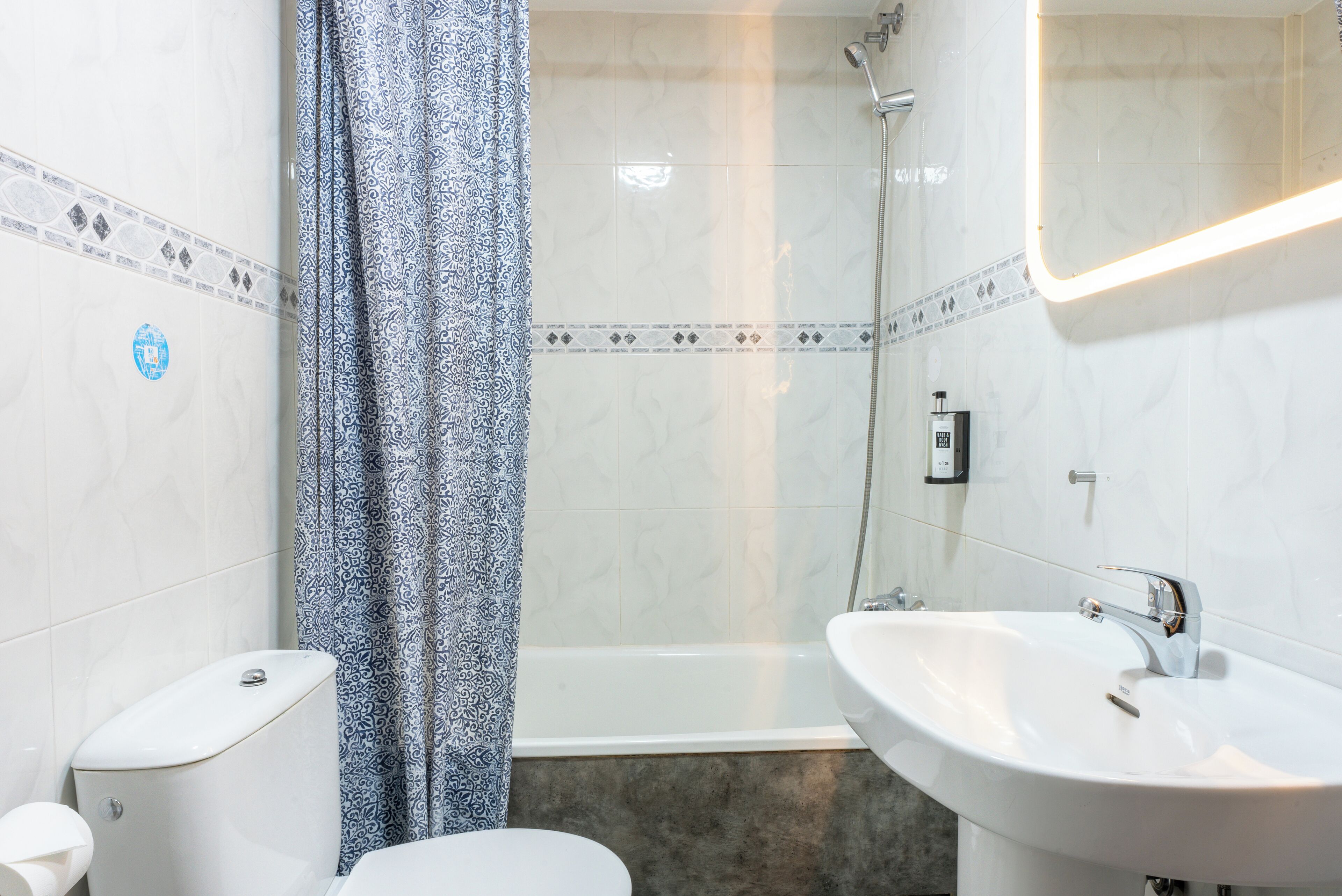 Une salle de bain avec des toilettes, une douche et un lavabo.