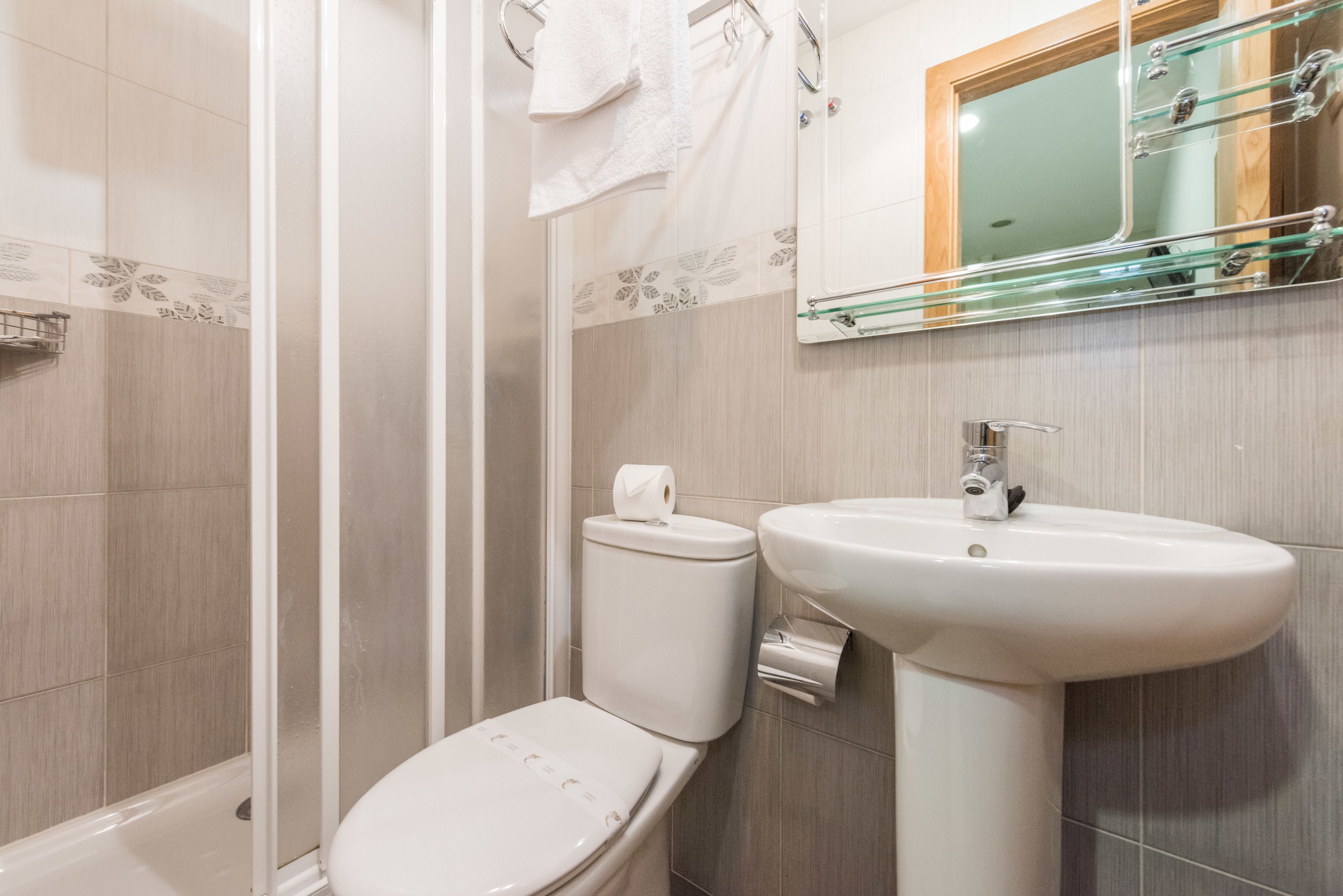 Un baño con inodoro, lavamanos y ducha.