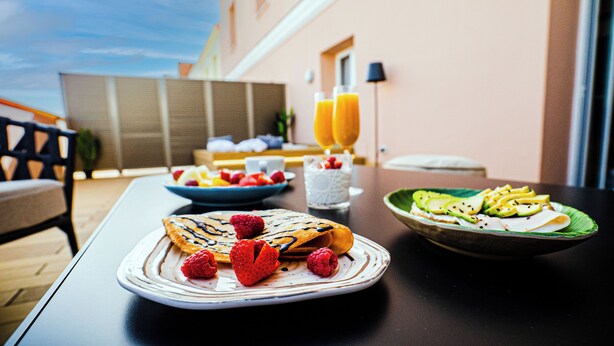 A table with breakfast items including pancakes, fruit, and a green salad. - Smartr Madrid Chueca  (Madrid)