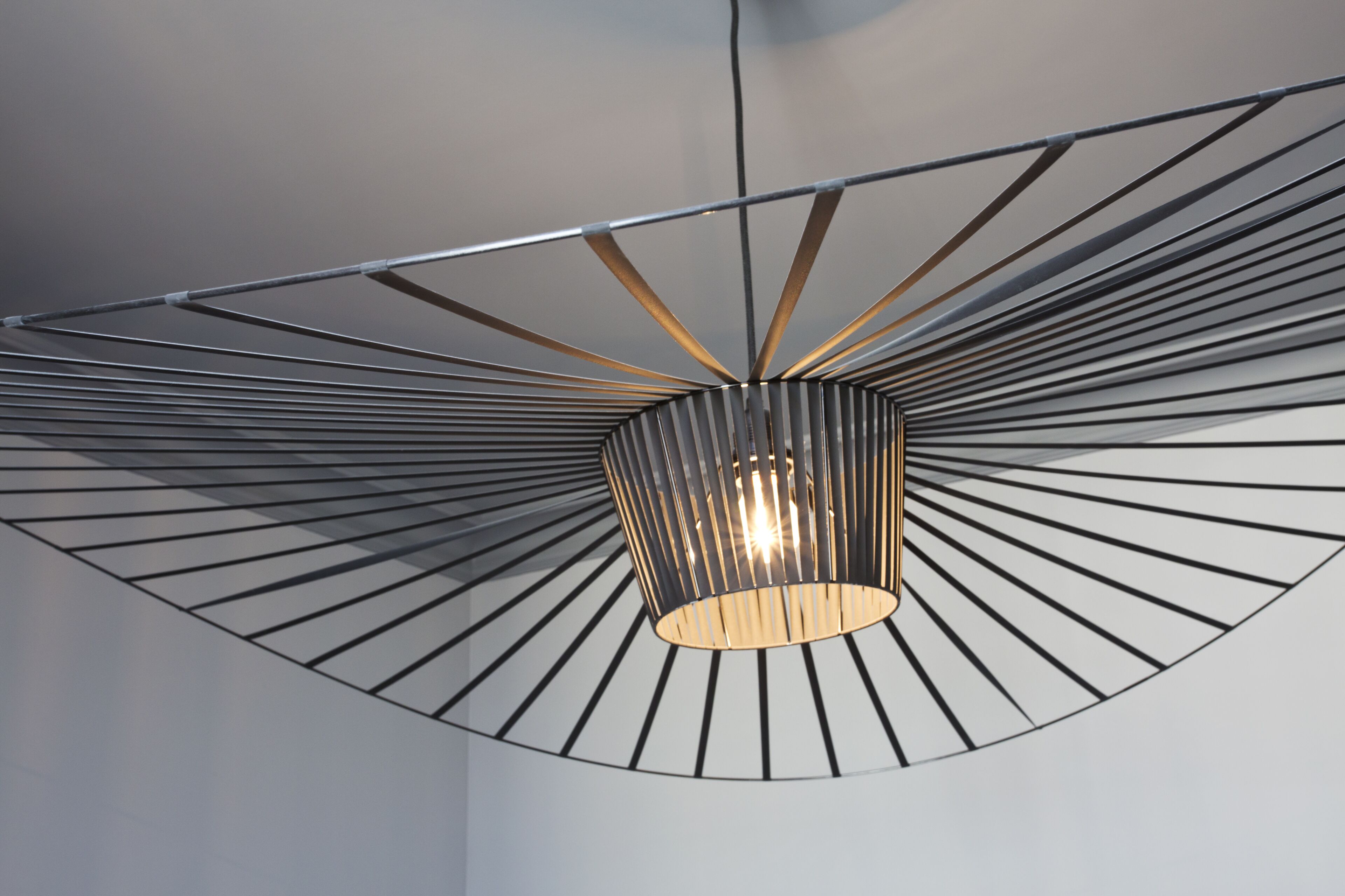 A modern ceiling with a radial design and a central light fixture.