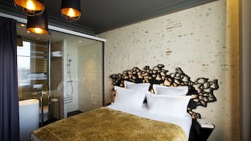 Habitación de hotel con cama, baño y una pared con textura particular.