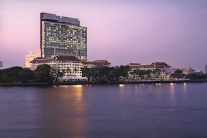 A high-rise hotel with multiple floors, a prominent 'AVANI' sign, and a waterfront view.