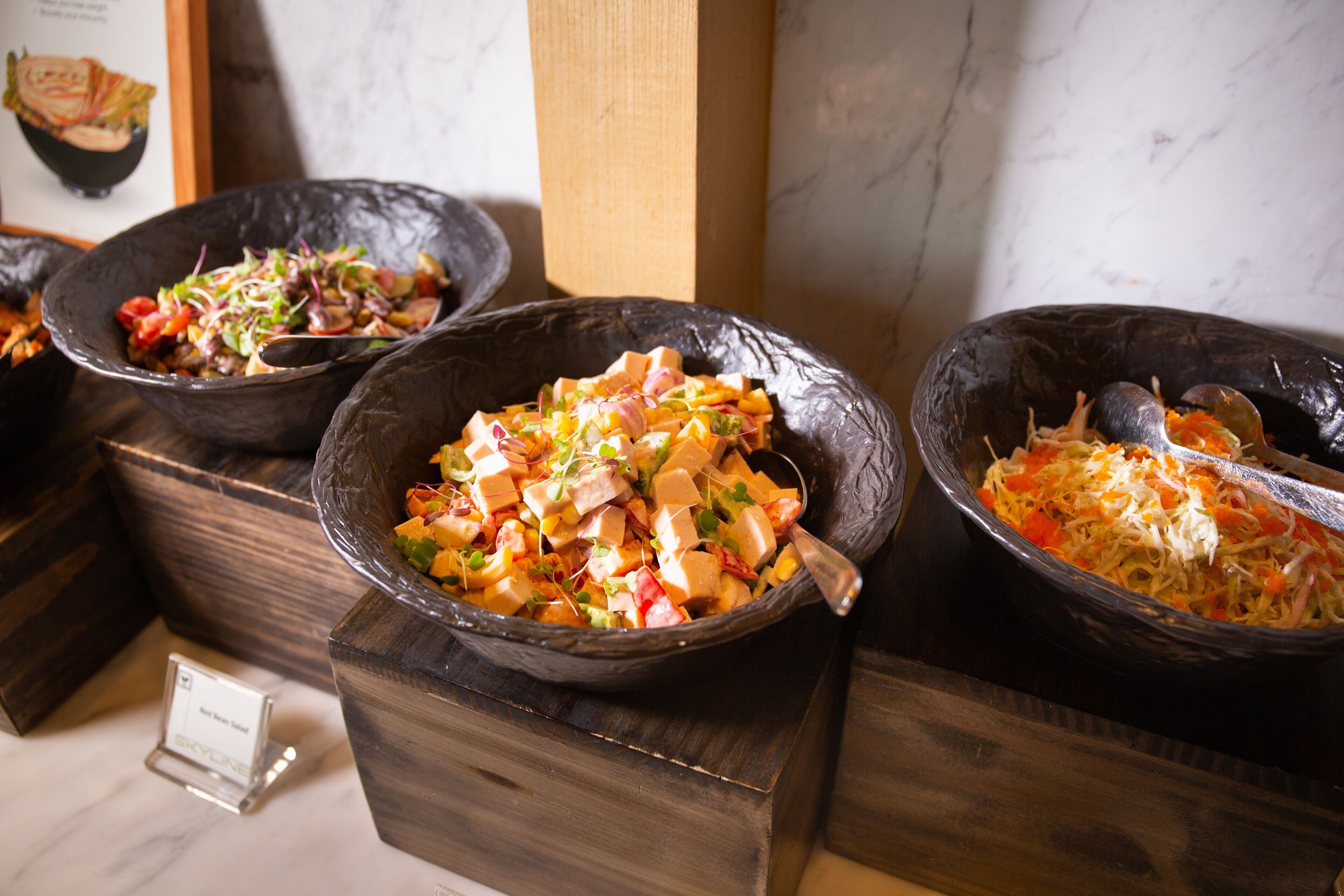 Three bowls of food on wooden blocks.
