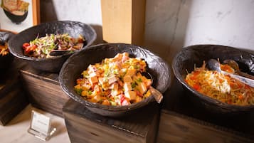 Three bowls of food on wooden blocks.