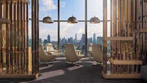 A modern office space with large windows, three pendant lights, and three white chairs. - Avani+ Riverside Bangkok Hotel (Bangkok)