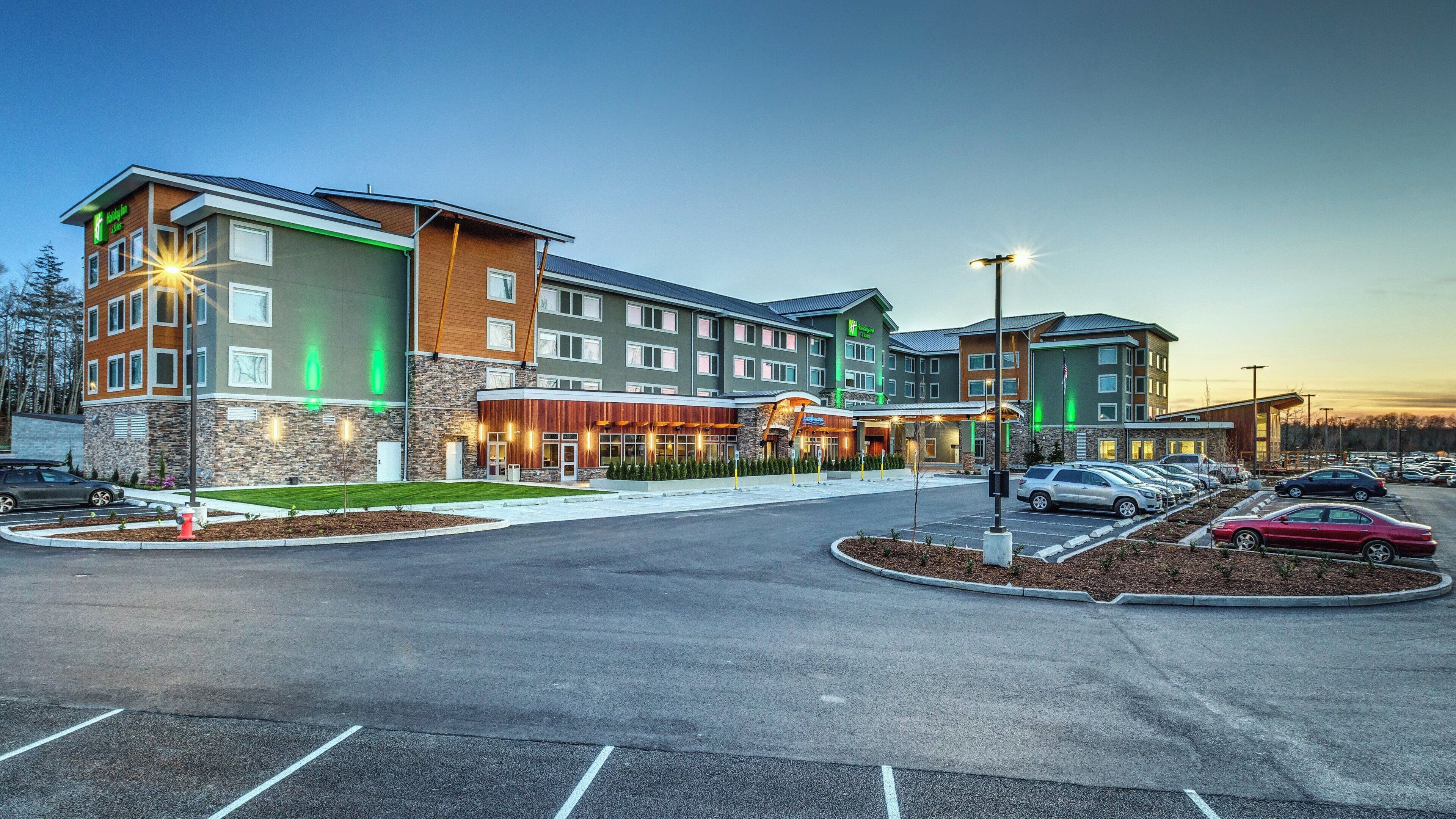 A multi-story hotel with a parking lot and a restaurant.