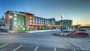 A multi-story hotel with a parking lot and a restaurant.