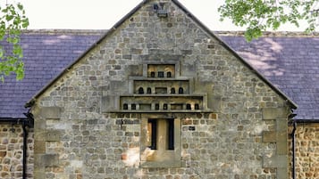 Ein Steinhaus mit einem großen Bogenportal und einem kleinen Fenster darüber.